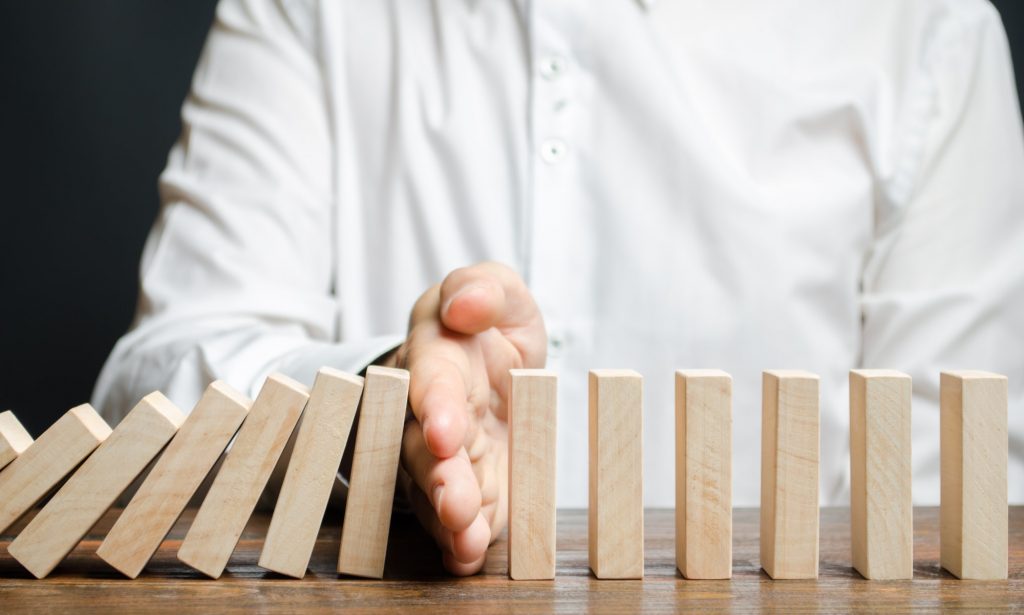 Businessman stops domino falling